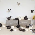 Table Display of native American artwork and ceramic animal heads on a wall