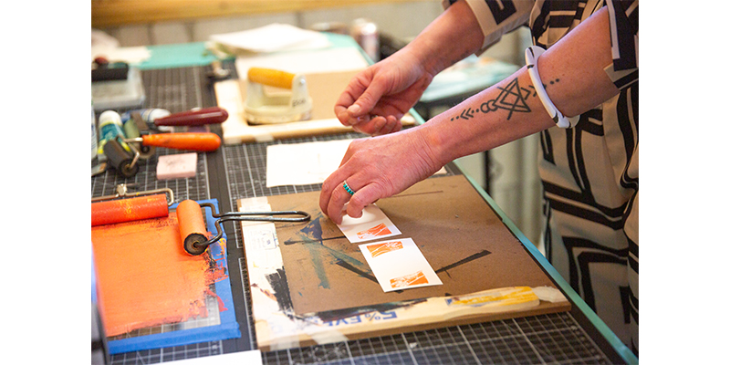 woman's hands arranging printmaking supplies