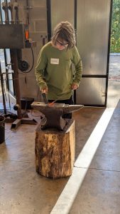 Youth participant practicing blacksmithing techniques during an ESSA Young Artist Program workshop