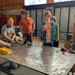 Students observing blacksmithing instruction during an ESSA Young Artist Program workshop