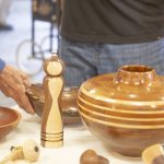 Assorted polished wooden bowls and turned objects displayed on a table.