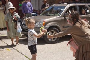 Performer interacts with child during the ArtRageous Parade in downtown Eureka Springs Arkansas