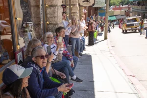 People line the sidewalks in downtown Eureka Springs during the ArtRageous Parade