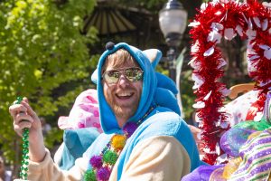 Parade participant in a blue costume smiling during the ArtRageous Parade in Eureka Springs