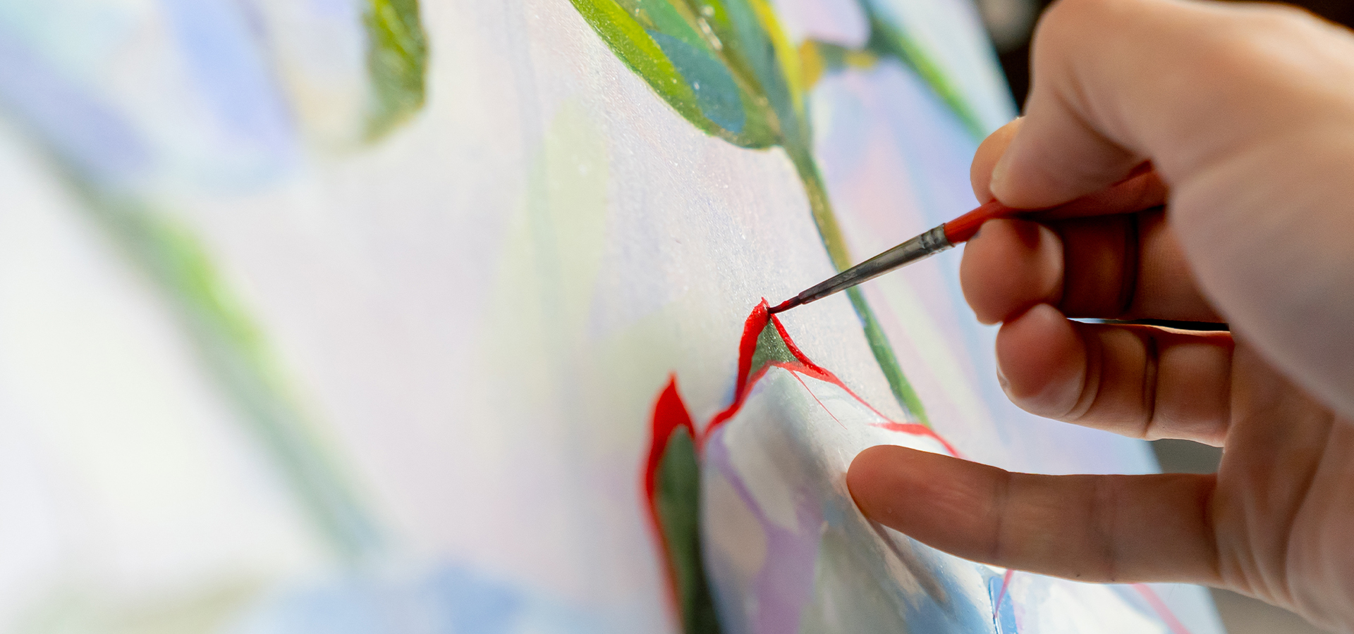 Close-up of an artist painting details on a canvas