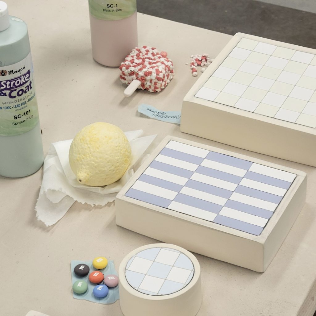 Ceramic lemon, popsicle, candies, and patterned display forms in progress on Erin Harris’s studio table.