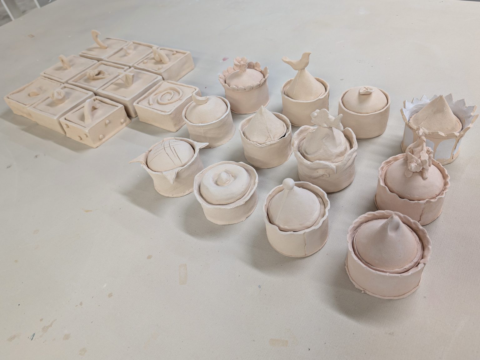 Bisque-fired ceramic boxes and lidded vessels made by ESSA staff during a class with artists Kaitlyn Cirielli and Erin Harris.