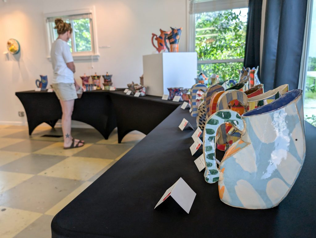 Guest views a collection of colorful patterned ceramic vessels by Kaitlyn Cirielli at ESSA.