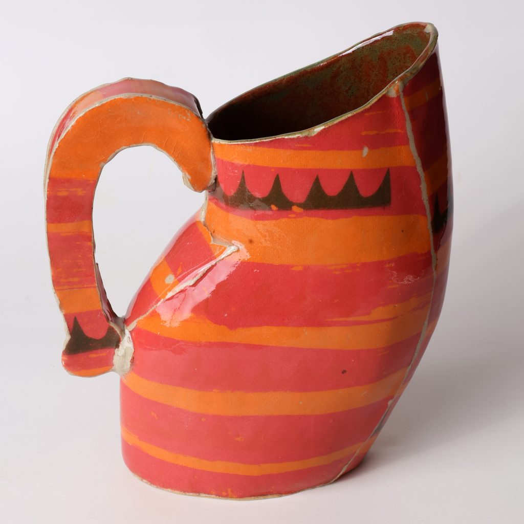 Ceramic pitcher by Kaitlyn Cirielli decorated with curved red and orange stripes and black geometric details.