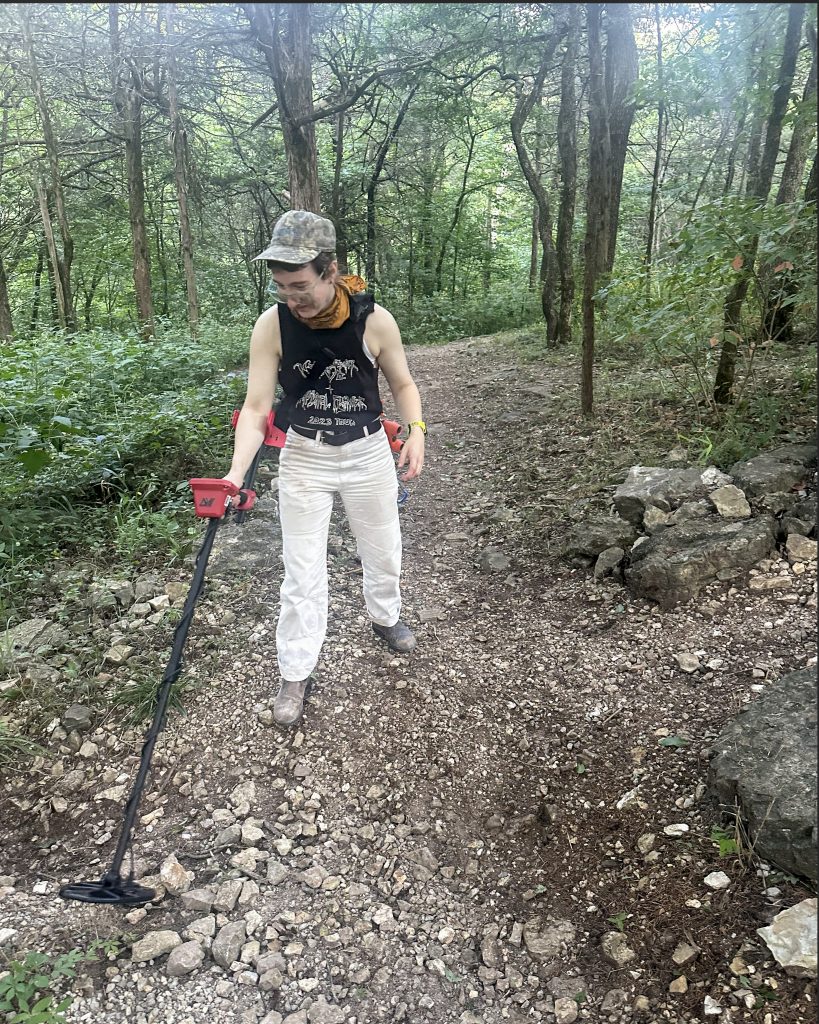 kaitlyn cirielli metal detectinKaitlyn Cirielli sweeps a metal detector over a rocky wooded trail in Northwest Arkansas.