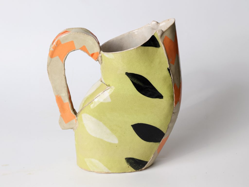 Hand-built ceramic pitcher by Kaitlyn Cirielli with pale green, orange, black, and cream patterns.